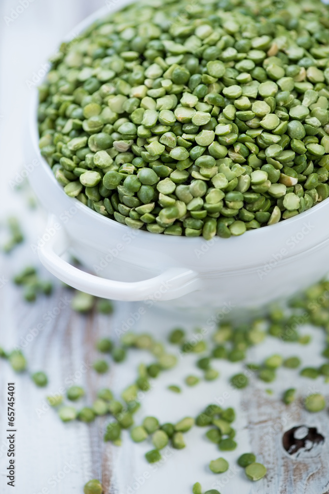 Split dried green peas in a glass bowl, vertical shot, close-up Split dried green peas in a glass bowl, vertical shot, close-up