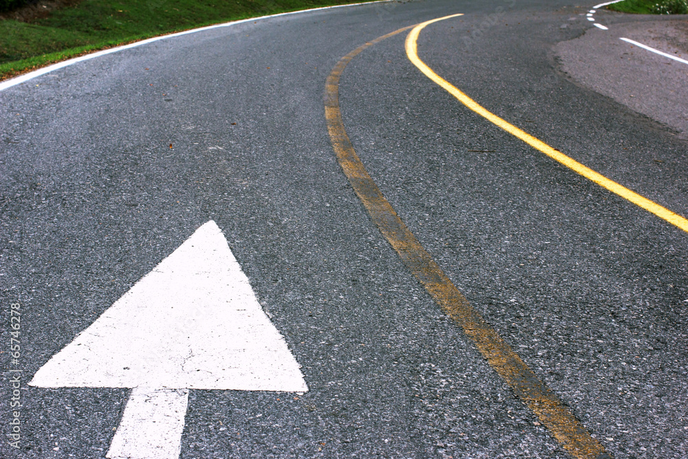 Road arrow direction sign on the asphalt road. Road arrow direction sign on the asphalt road.