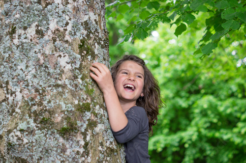 Happy laughing Girl holding big tree