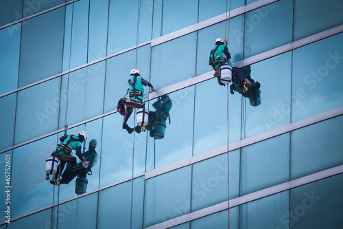 group of workers cleaning windows service on high rise building