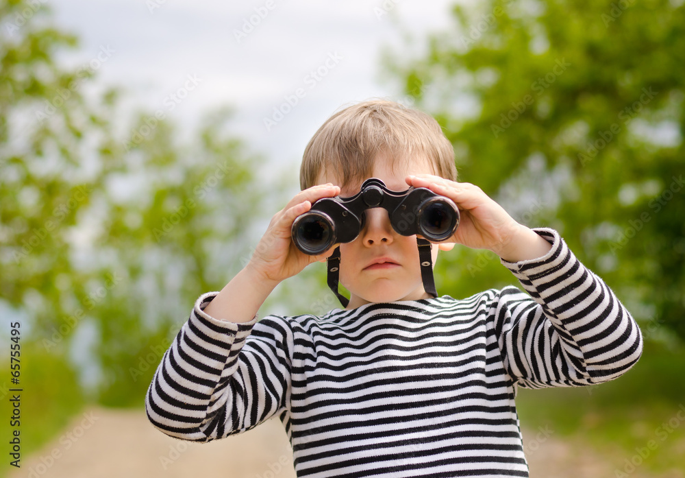 Little boy scanning the woods with binoculars Little boy scanning the woods with binoculars