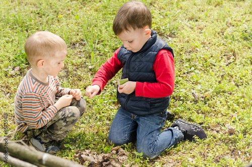 Two small boys lighting a fire in woodland © Daddy Cool