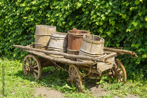 Vintage, wooden cart with wooden barrels and buckets photo