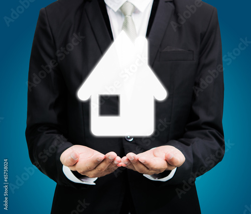 Businessman standing posture hand holding house icon isolated