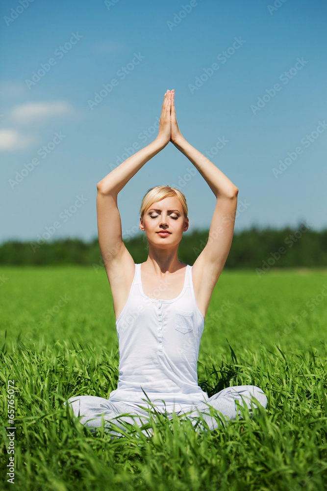 Young beautiful woman practicing yoga meditating outdoors in Young beautiful woman practicing yoga meditating outdoors in