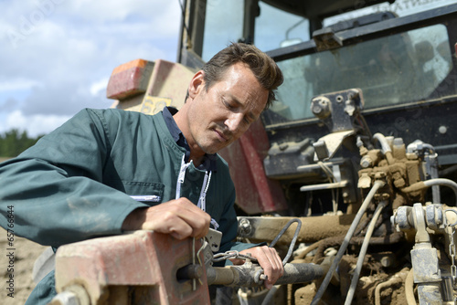 Farmer working on tractor in farming land