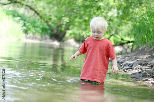 Fototapeta Naklejka Na Ścianę i Meble -  Young Child Playing Outside in the River