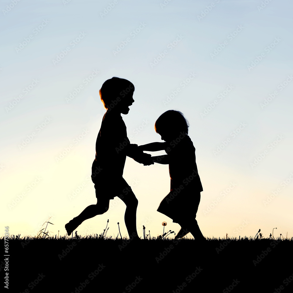 Silhouette of Happy Little Children Dancing at Sunset Silhouette of Happy Little Children Dancing at Sunset