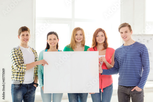 students at school holding white blank board © Syda Productions