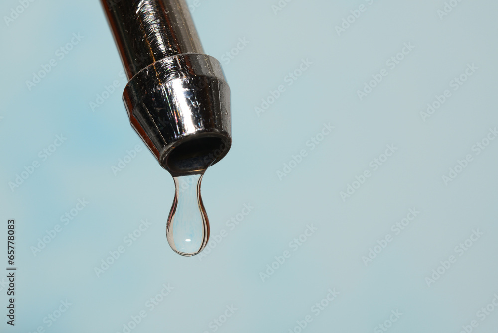 kitchen tap with water drops on a light-blue background kitchen tap with water drops on a light-blue background