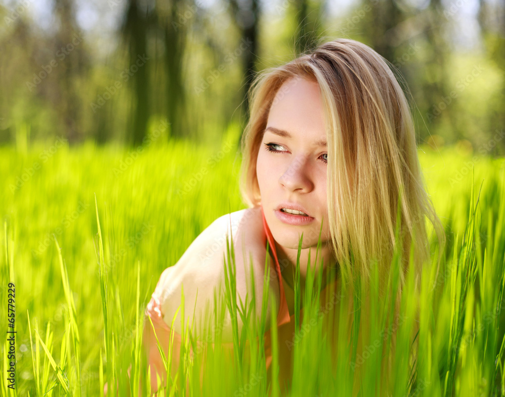 Summer girl in green grass on a background of nature Summer girl in green grass on a background of nature