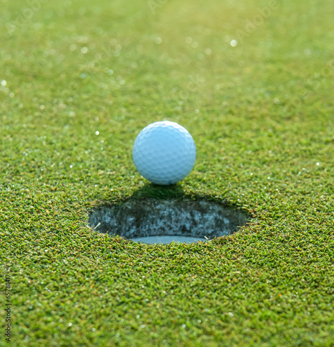 Golf Ball Rests at Edge of Hole Before Falling In