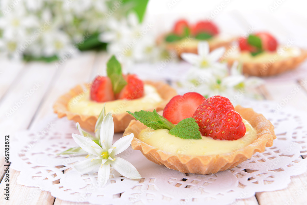 Tasty tartlets with strawberries on table close-up Tasty tartlets with strawberries on table close-up