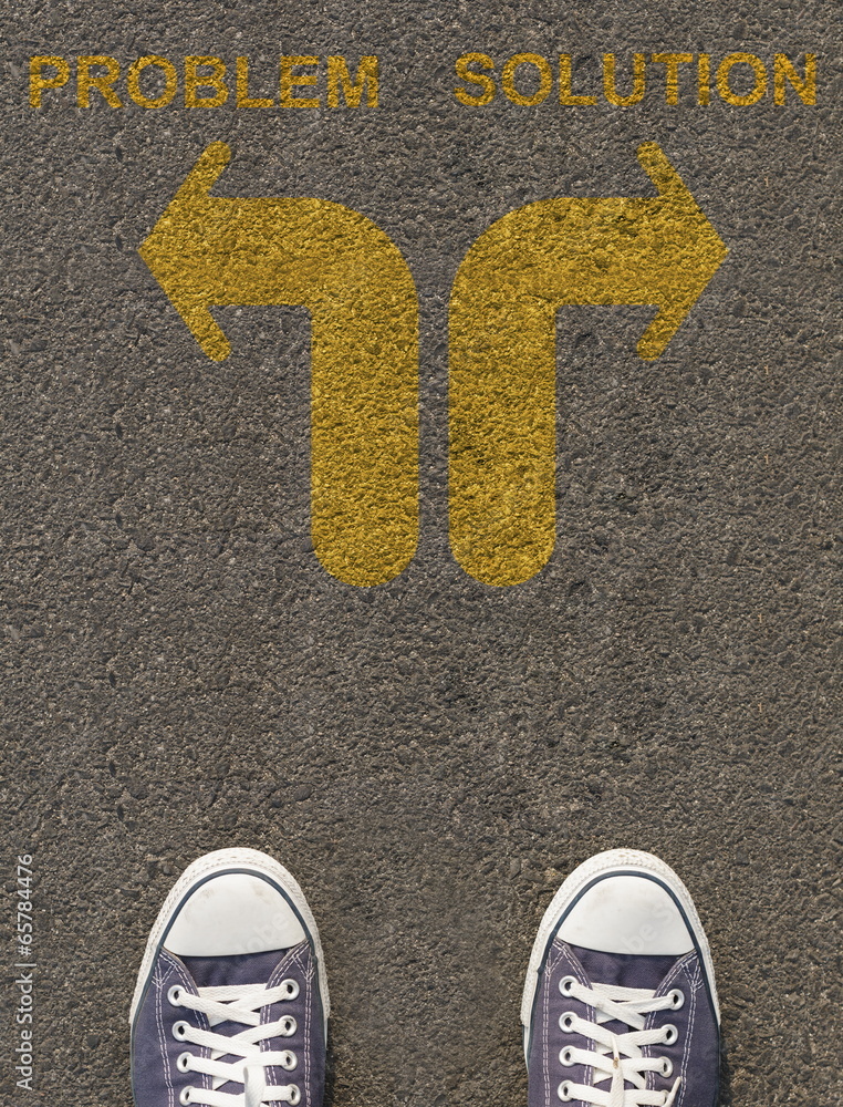 Obraz premium Pair of shoes standing on a road with arrow