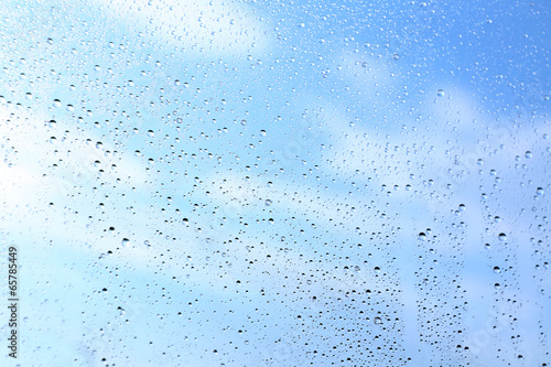 Wet transparent umbrella on sky background