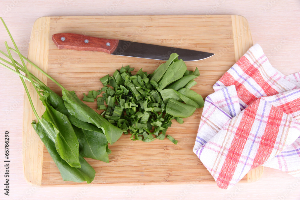 Chopped greens with knife on cutting board on table Chopped greens with knife on cutting board on table