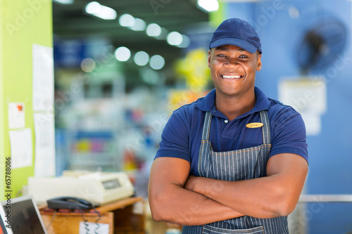 african supermarket cashier standing at checkout photo