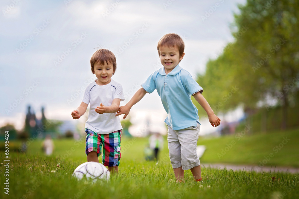 Fototapeta premium Two cute little boys, playing football