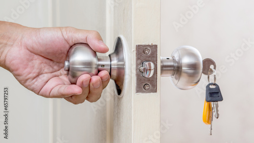 Hand holding door knob with keys photo