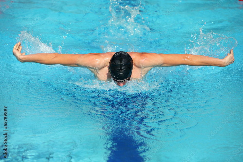 swimmer in cap performing the butterfly stroke