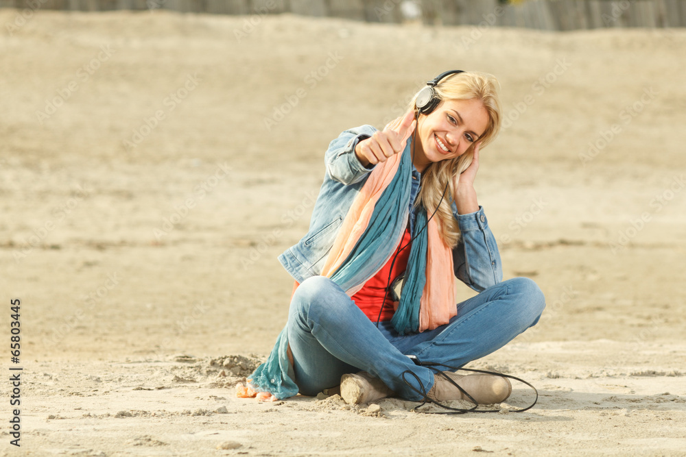 Happy woman with thumbs up  listening to music with headphones