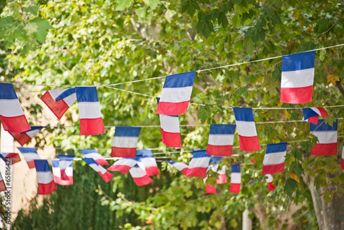 French flags, blue white and red garlands decorating a village square in summer, Bastille day, July 14th national day celebration concept