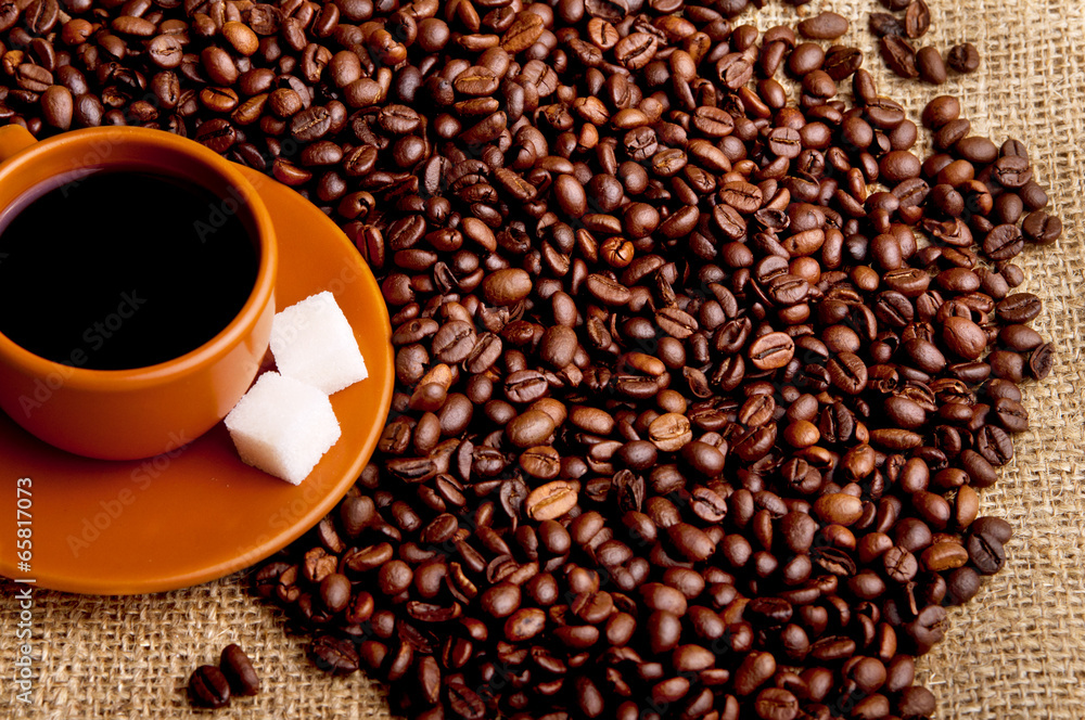 Fototapeta premium Cup of coffee with refined sugar and coffee beans.