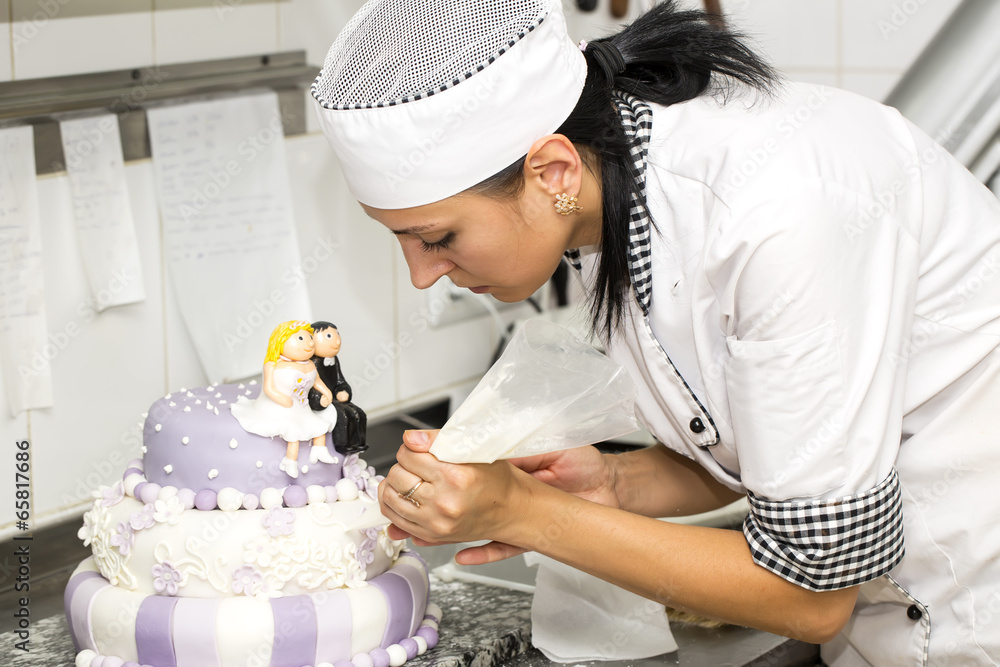 pastry chef decorates a cake in a candy store pastry chef decorates a cake in a candy store