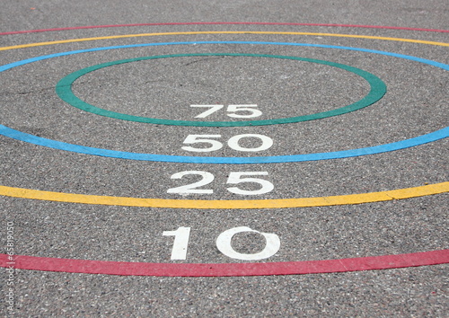 Quoits game with winning circles on asphalt