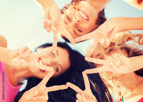 girls looking down and showing finger five gesture