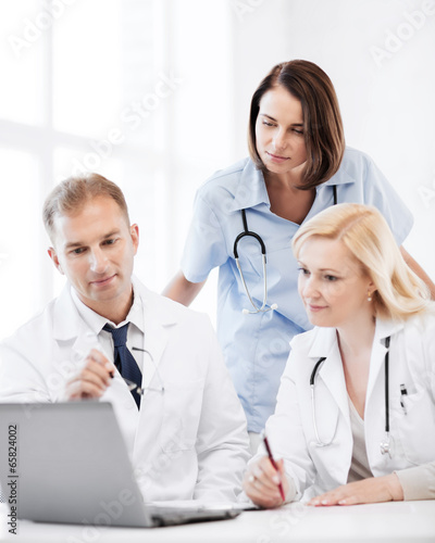 doctors looking at laptop on meeting