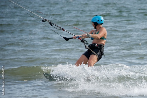 Female kite surfer looking away amid spray