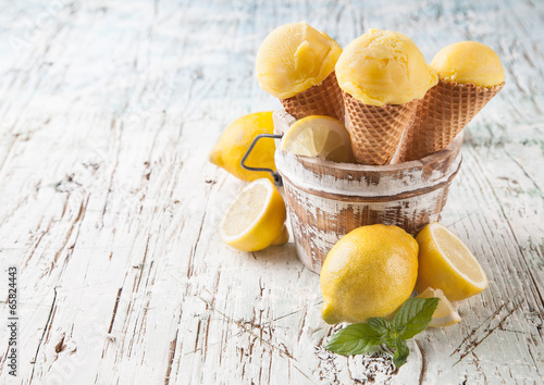 Fresh ice cream scoops in cones on wood