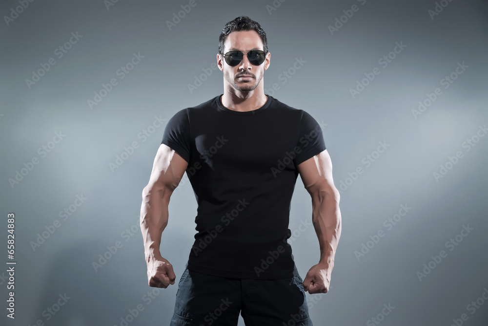 Combat muscled action hero man wearing black t-shirt with pants