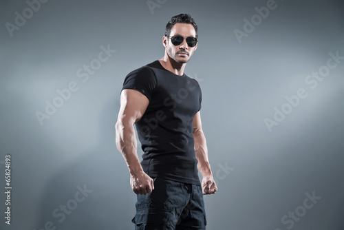Photography Combat muscled action hero man wearing black t-shirt with pants