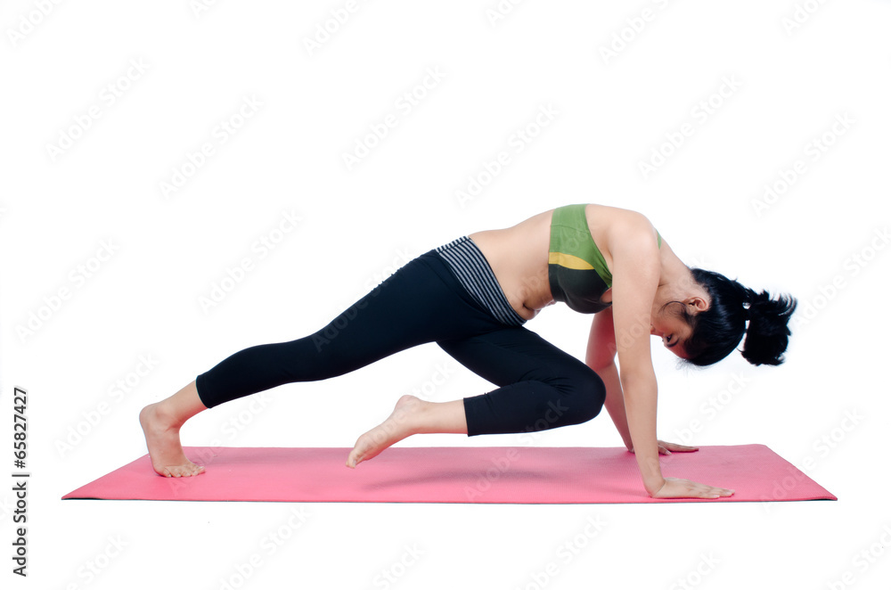 Beautiful woman indoor exercising using pink yoga mat