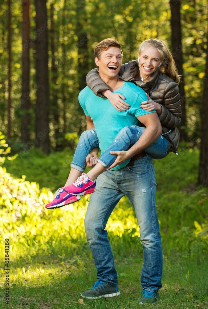 Fototapeta premium Happy teenage couple having fun outdoors on sunny day