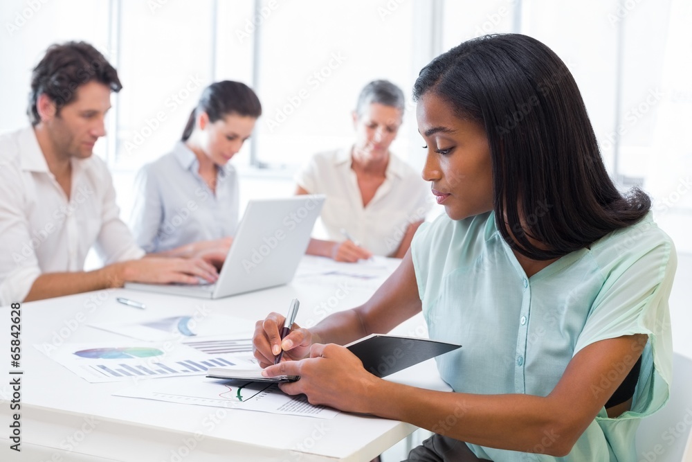 Casual businesswoman taking notes during meeting