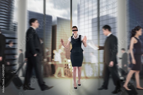 Composite image of redhead businesswoman in a blindfold