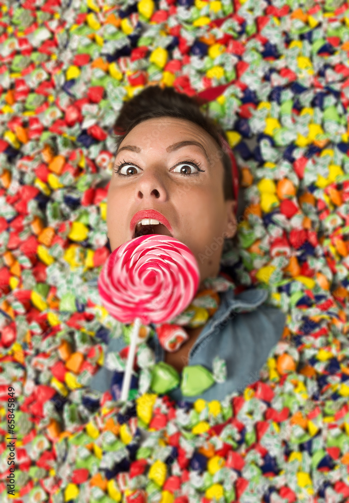 girl hiding under a lot of candy