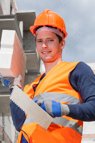 Builder with brick and spatula