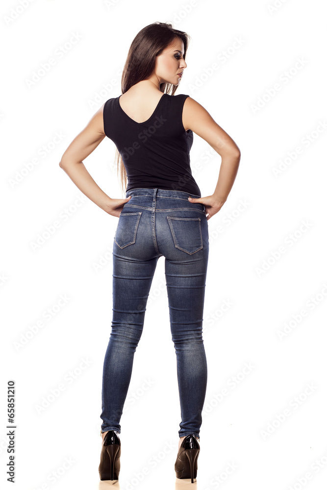 rear view pretty young woman in jeans posing on a white rear view pretty young woman in jeans posing on a white