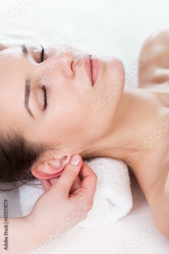 Woman having ear massage