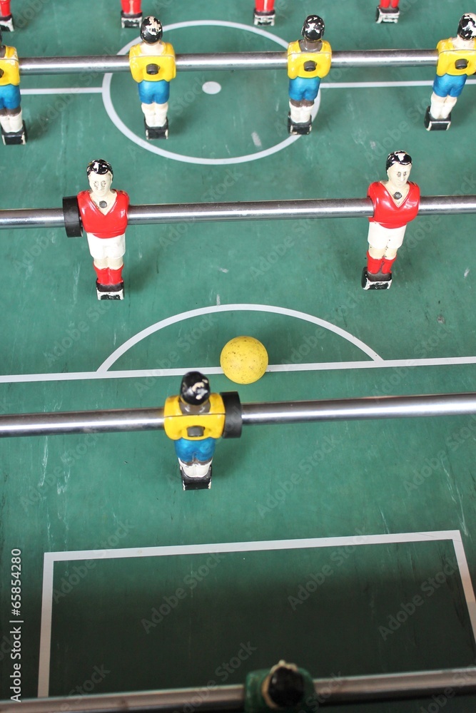 Fototapeta premium Foosball football soccer tabletop in team colors red white yellow and blue