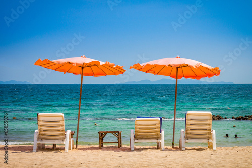 Fototapeta Naklejka Na Ścianę i Meble -  Beach umbrella and sunbath seats and side table