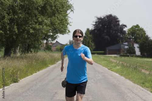 Adult caucasian man running on the road