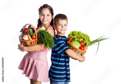 Smiling kids with vegetables in basket