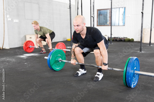 Group trains deadlift at crossfit center