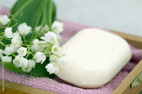 Spa setting of towels, soap and lilies of the valley