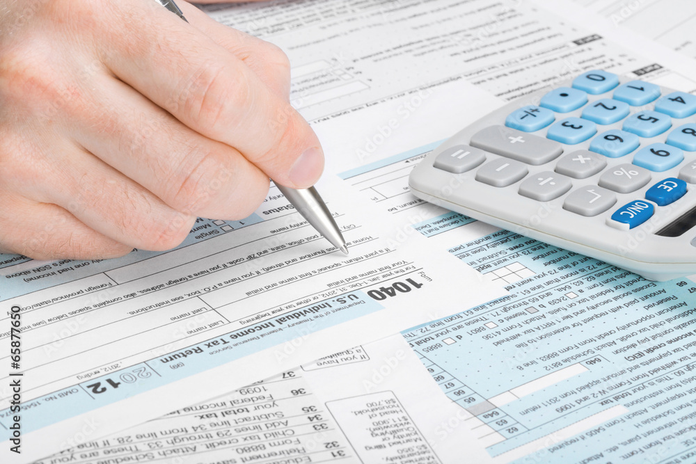 USA Tax Form 1040 - man filling out tax form USA Tax Form 1040 - man filling out tax form